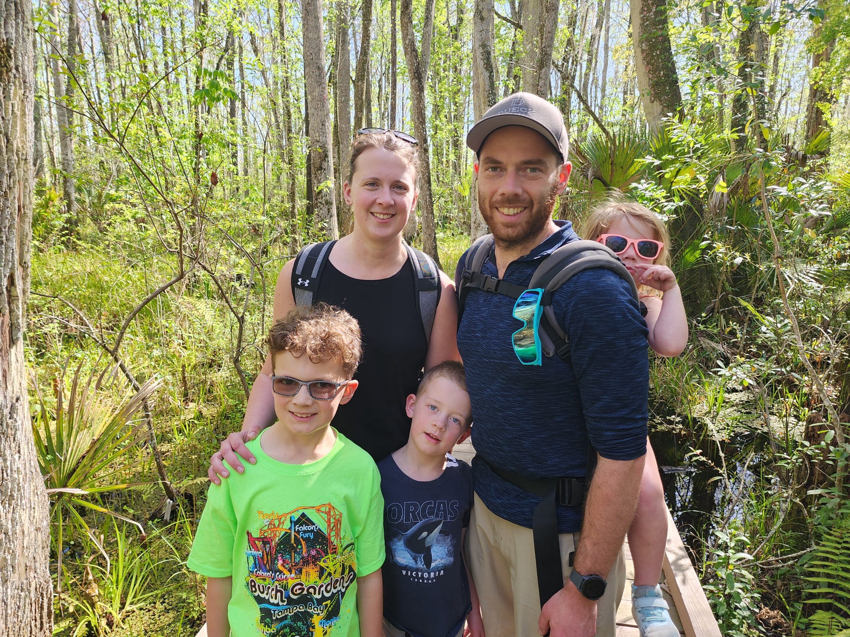 Josh and his young family with a green background.