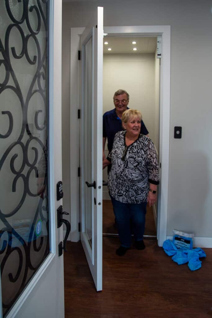 An elderly couple stepping out of elevator